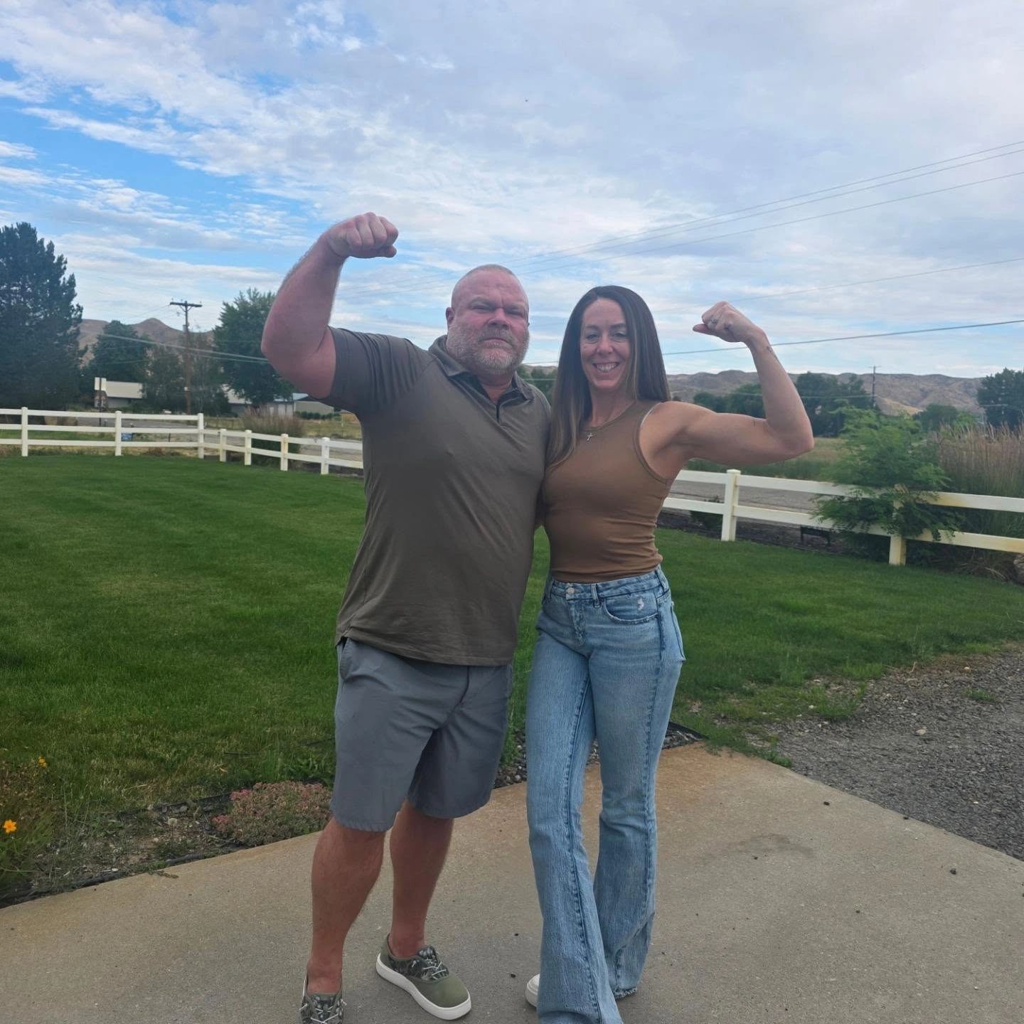 Man and woman flexing their arms outdoors — Gym Founders Missy & Aaron Gardner